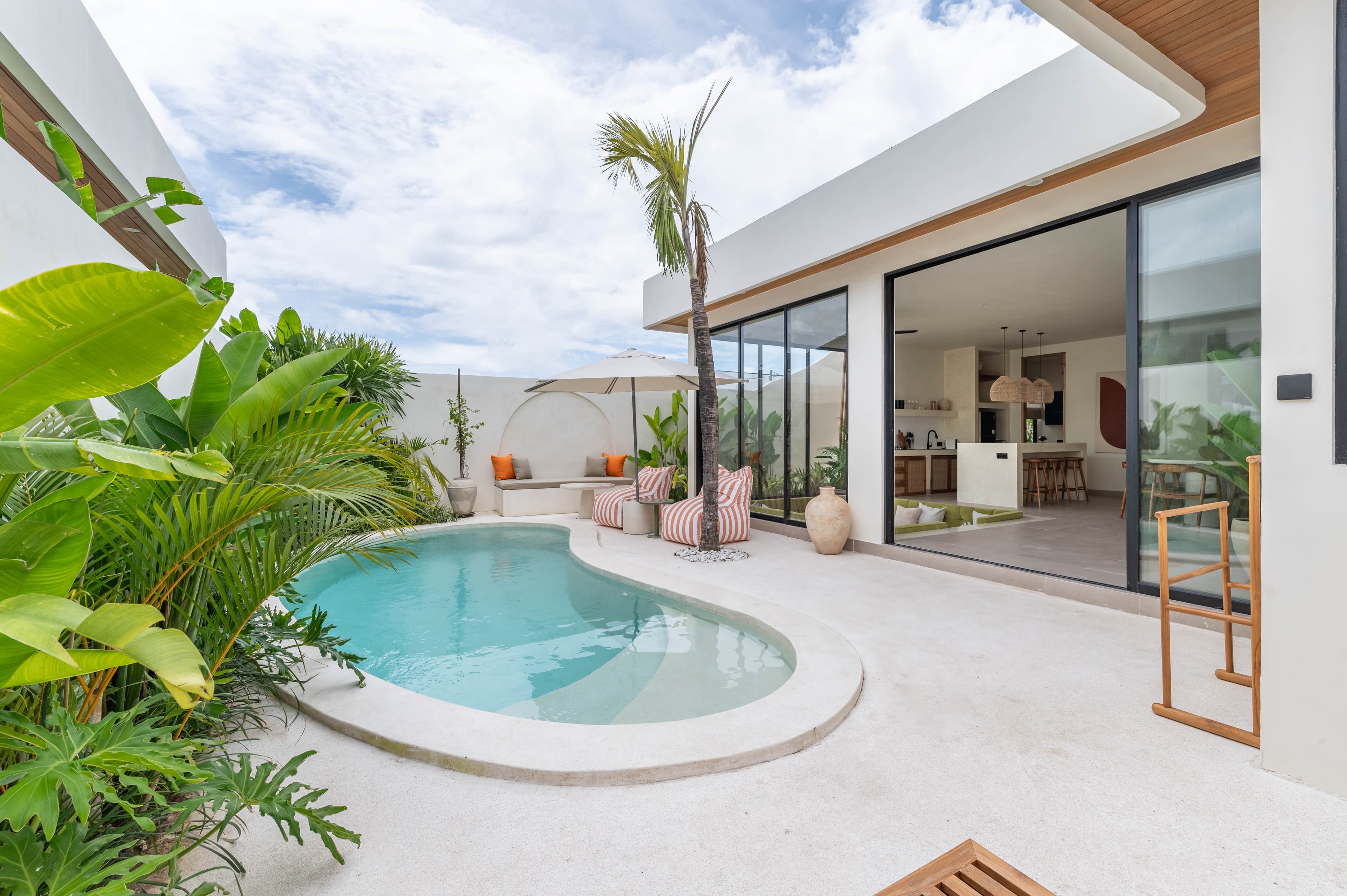 Pool, palm and open-plan living area at Villa Bayu Sari
